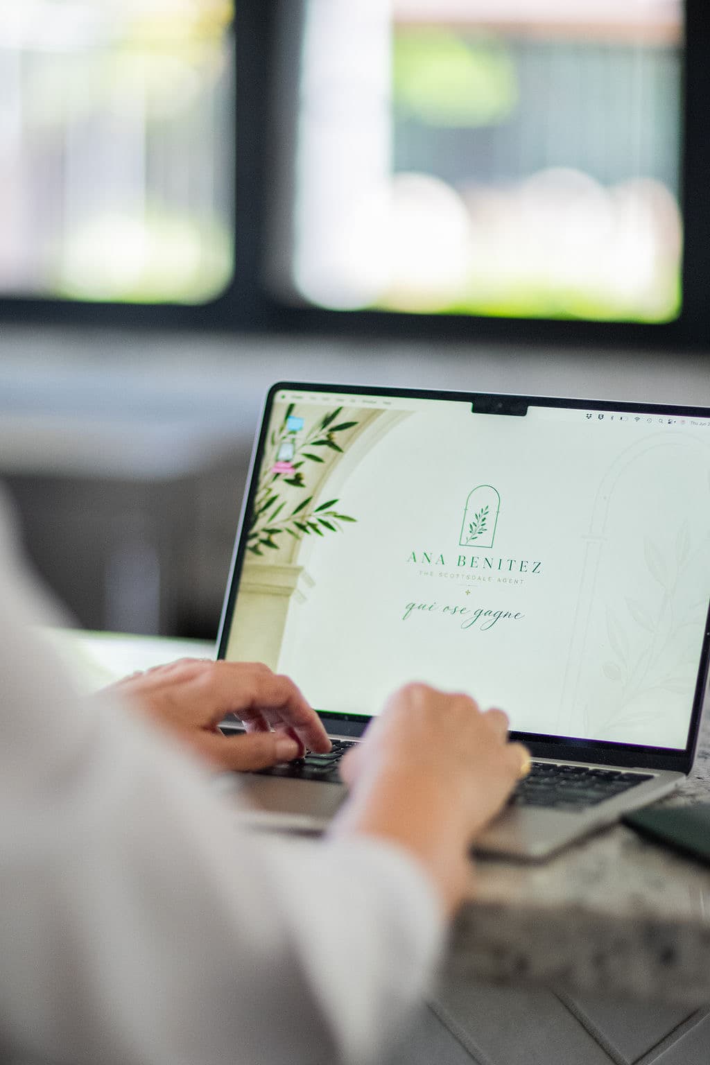 Ana working on a laptop with The Scottsdale Agent branding.